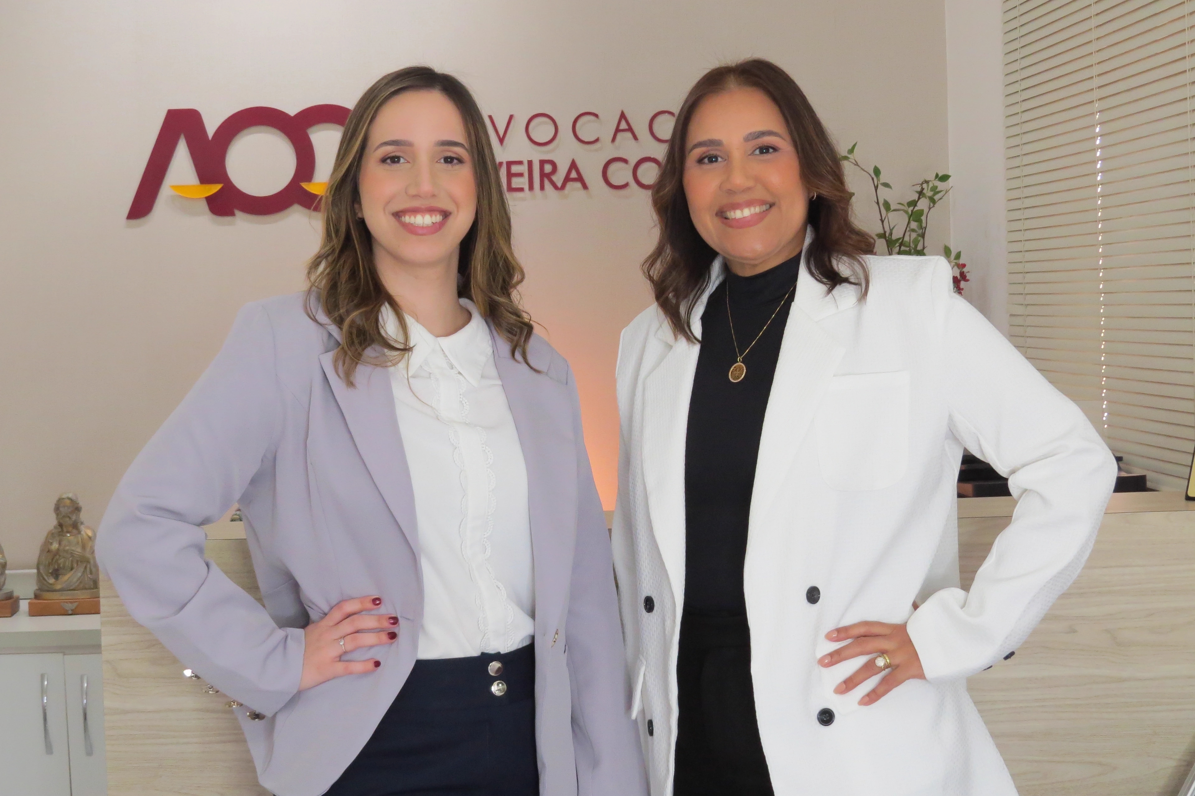 Duas advogadas do Advocacia Oliveira Costa na recepção do escritório, sob a marca da banca